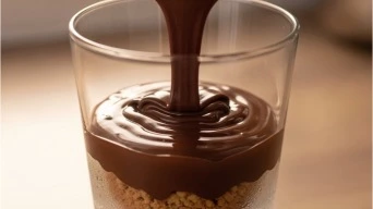 Pouring chocolate cream layer for Valentine dessert
